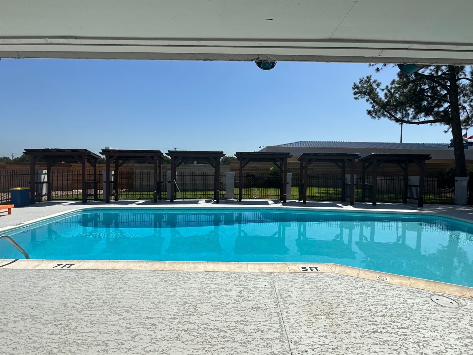 Pool with a row of covered pergolas